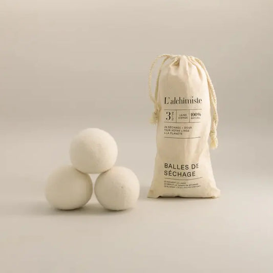 Trois balles de séchange en laine off-white et un sac à cordon pour un séchage écologique