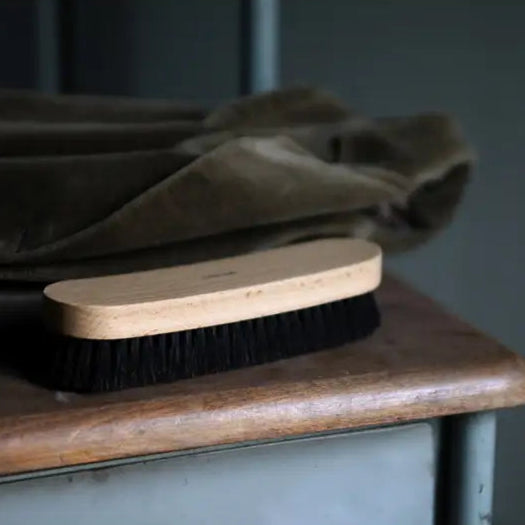 Brosse à vêtements avec manche en bois et poils noirs pour prendre soin de tes vêtements