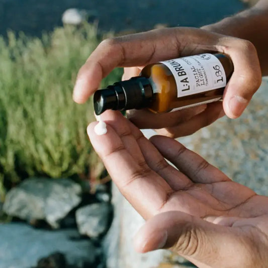 Main qui presse la crème visage Camomille et Lavande pour lutter contre radicaux libres