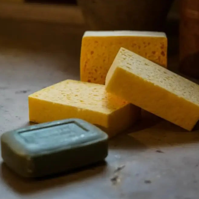 Barre de savon olive-green et éponges jaunes pour un entretien plus sain