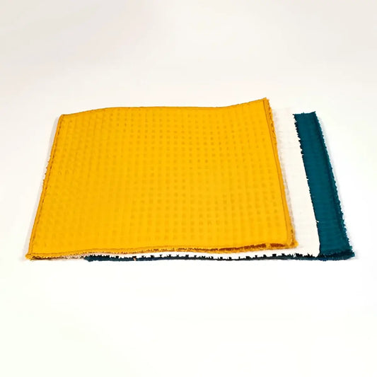 Lingette lavable Essuie tout bleu paon pliée jaune à bord bleu, zéro déchet