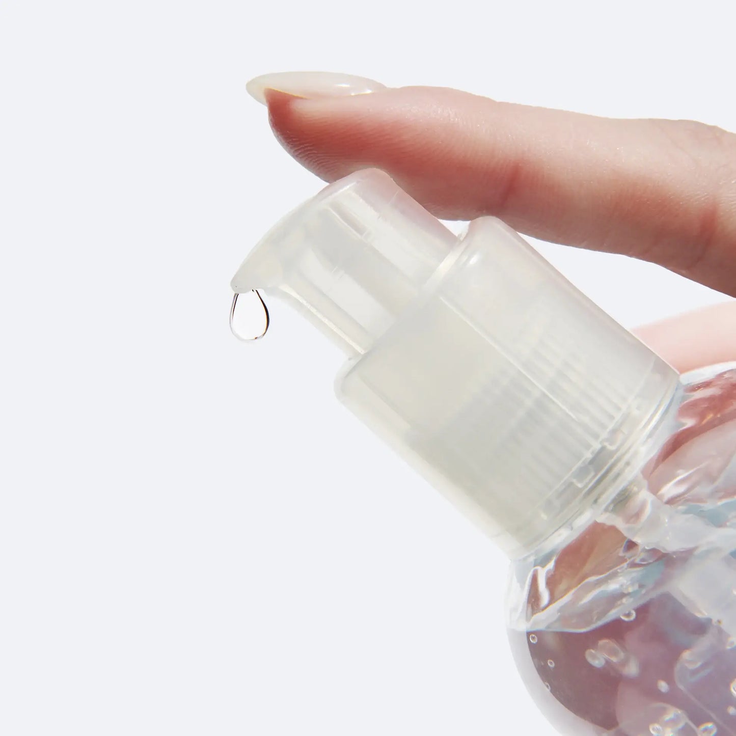 Bouteille pompe claire dispensant une goutte de Gel Joy Jolly à texture soyeuse