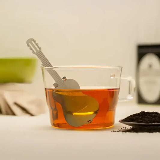 Infuseur à thé guitare en métal dans un verre de thé ambré pour un tea time cool