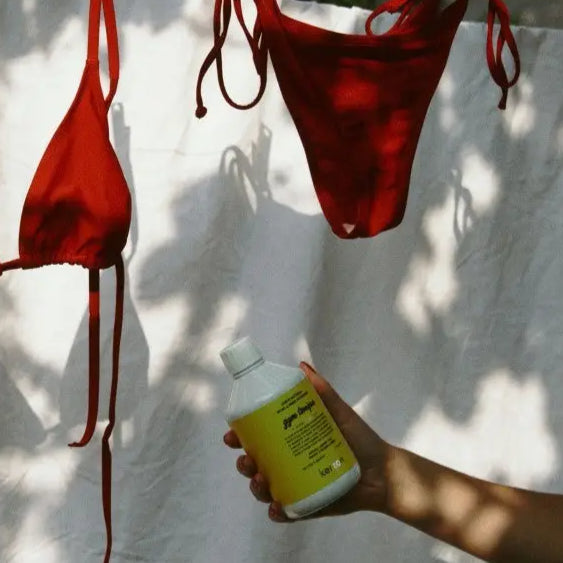 Main de Lush tenant lessive naturelle pour fibres techniques 500ml au parfum subtil