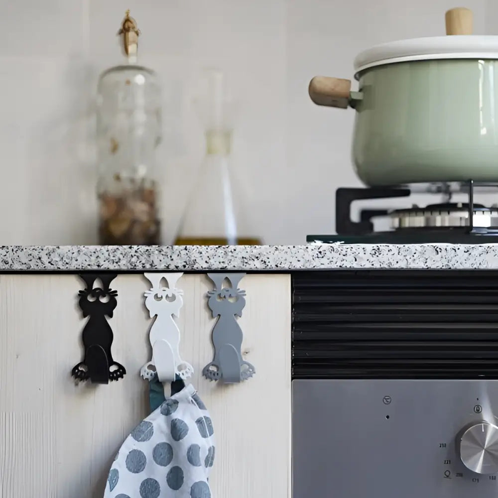 Trois crochets aimants chat Curious Cat X3 en métal noir, blanc, gris sur porte de tiroir, finition soignée et qualité durable