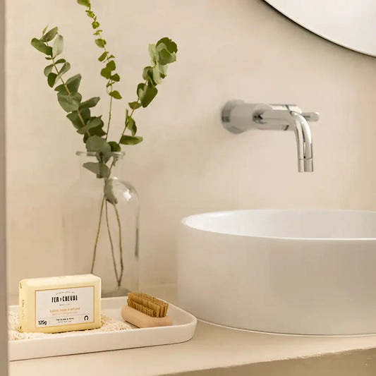 Photo d’un lavabo moderne avec robinet mural et savon solide thé blanc et yuzu