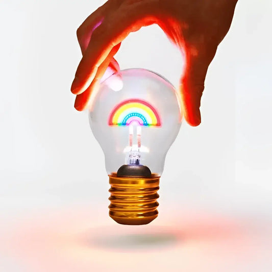 Main dans le filament lumineux de l’ampoule arc en ciel sans fil pour ambiance unique