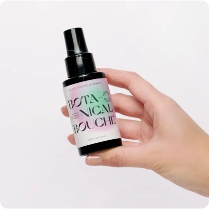 Main tenant un flacon pulvérisateur noir Bain De Bouche Botanical pour microbiome buccal équilibré