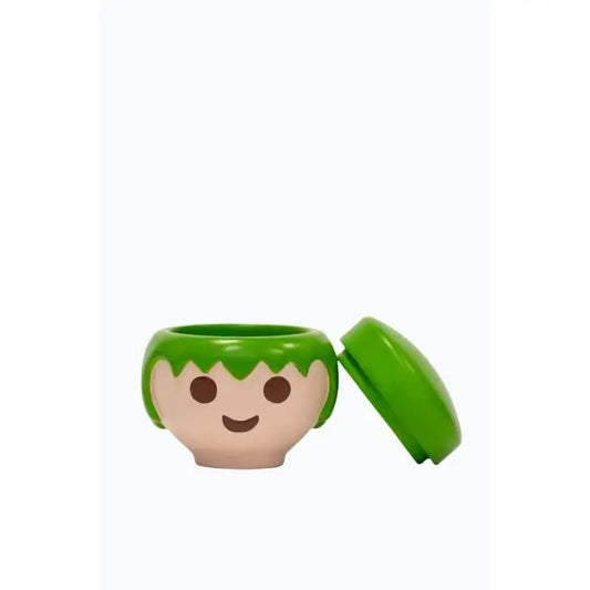 Tête Playmobil en plastique vert, sourire et cheveux courts, dans boîte verte au design ludique