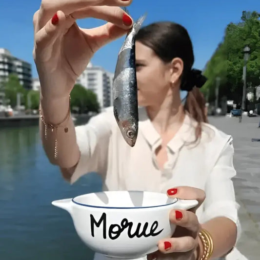 Femme tenant un poisson dans un bol breton revisité pour une touche d’originalité