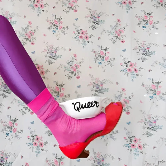 Leg portant chaussette rose et chaussure rouge écrasant bol breton revisité queer