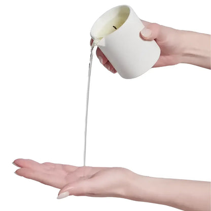Bougie de massage en céramique blanche avec pierre gua dispensant liquide sur main