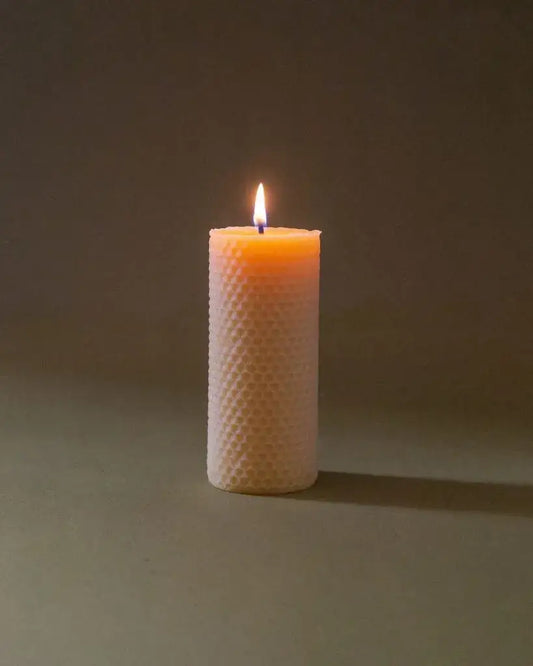 Bougie en cire d’abeille Ambroise allumée à texture nid d’abeille