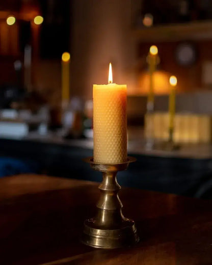Bougie en cire d’abeille Ambroise allumée dans écrin raffiné