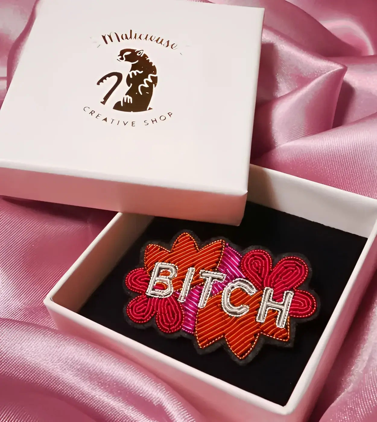 Broche Bitch brodée en fils brillants avec BITCH en blanc sur floral aux couleurs vibrantes