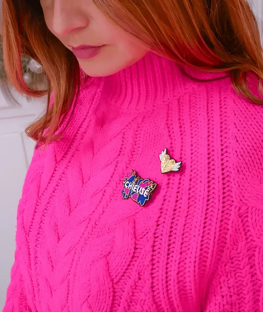 Femme en pull rose col roulé broche brodée message audacieux bijou textile