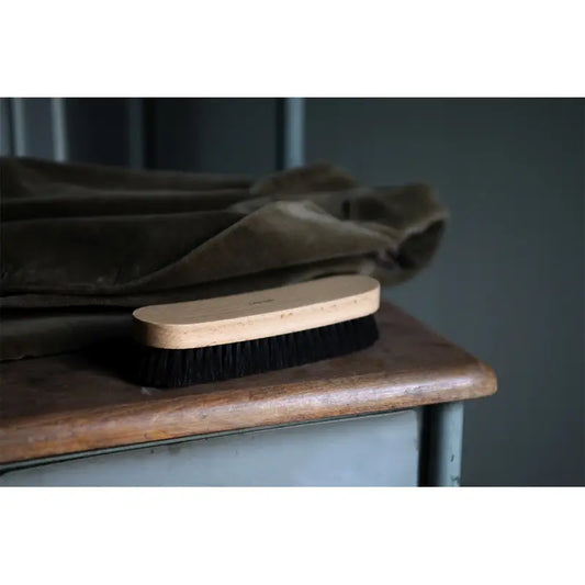 Brosse à vêtements en bois pour prendre soin des habits