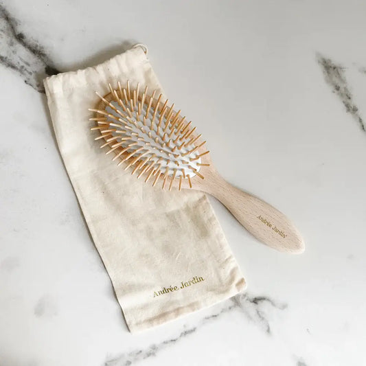 Brosse démêlante en bois clair avec poils naturels, agréable à utiliser et pochette assortie