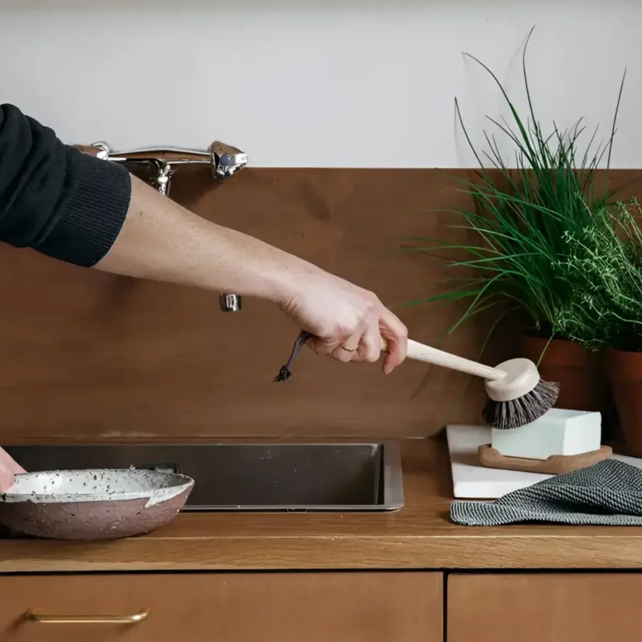 Main holding a brosse à vaisselle naturelle souple pour vaisselle naturelle