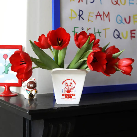 Vase cache-pot ramen avec des tulipes rouges, design ludique et élégant