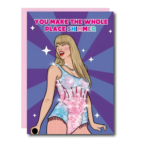 Carte postale Taylor Swift: femme blonde en body pailleté rose et bleu sur fond étoilé violet, enveloppe incluse