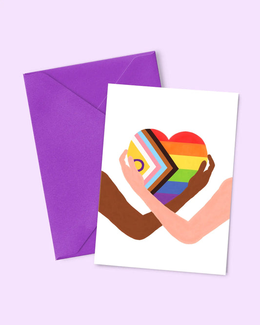 Carte rainbow heart : carte blanche avec cœur arc-en-ciel multicolore tenu par deux mains, peau brune et claire, papier 300g, enveloppe assortie