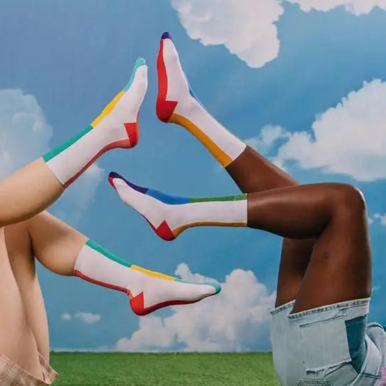 Quatre jambes en chaussettes arc-en-ciel pour une bonne humeur aux couleurs éclatantes