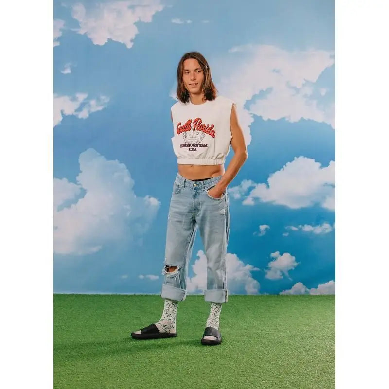 Personne en crop blanc, jeans déchirés clairs, chaussettes Chausettes fromage bleu, slides noirs : cadeau original, confort optimal