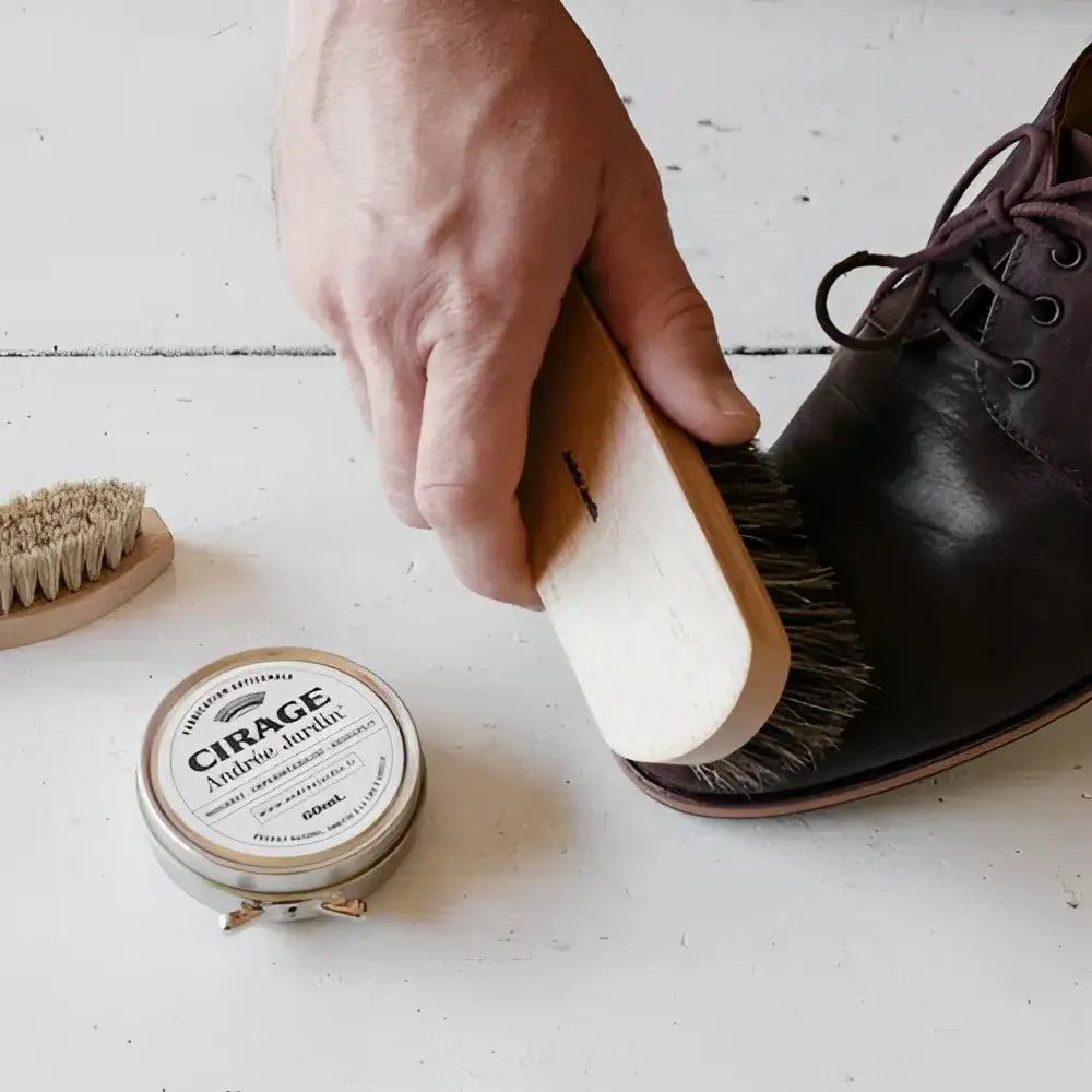 Main polissant chaussure cuir foncé avec brosse bois et cire d’abeille naturelle