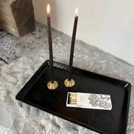 Deux bougies fines carbone allumées en forme conique, lumière douce pour décoration intérieure ambiance chaleureuse