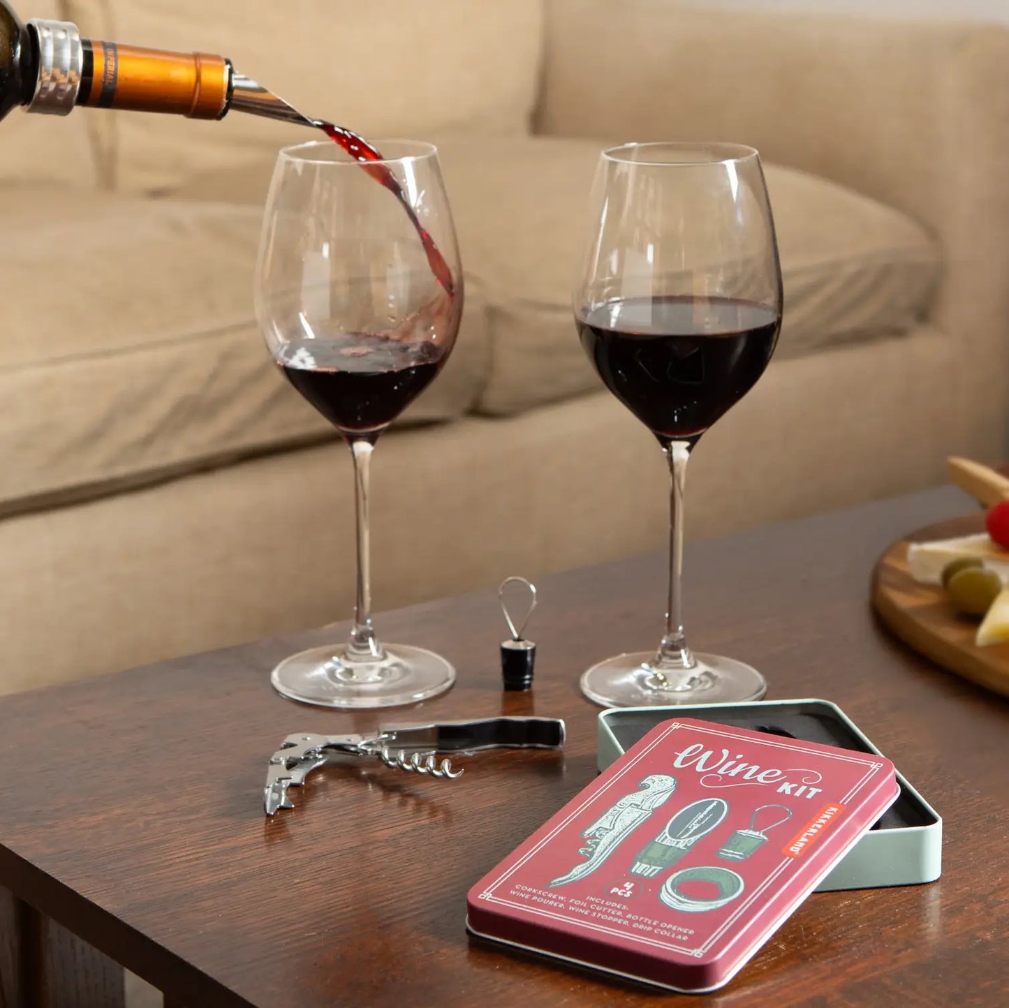 Vin rouge versé dans un verre, coffret d’accessoires pour le vin design soigné