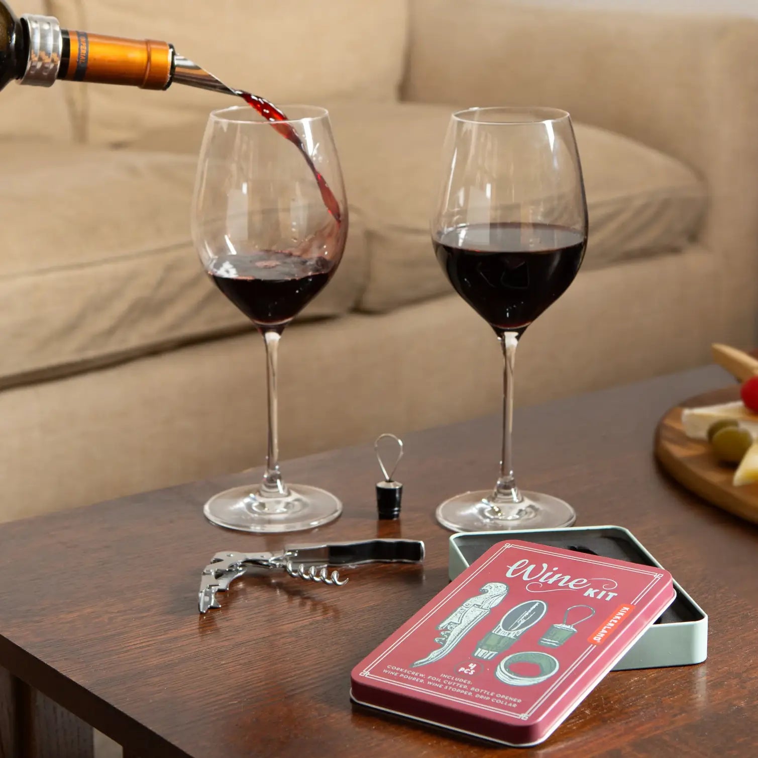 Vin rouge versé dans un verre, coffret d’accessoires pour le vin design soigné