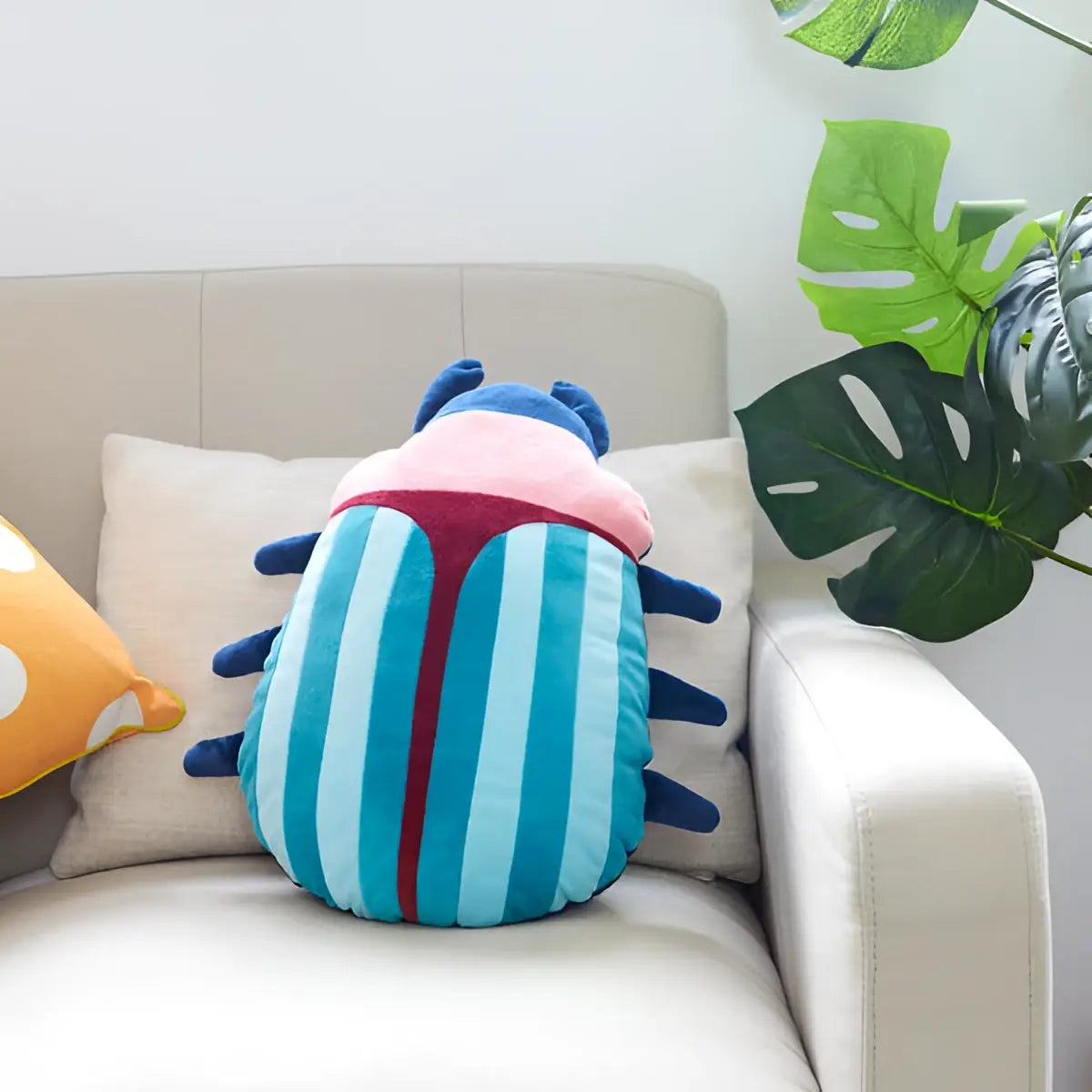 Coussin scarabée rose en peluche rayé bleu avec tête rose