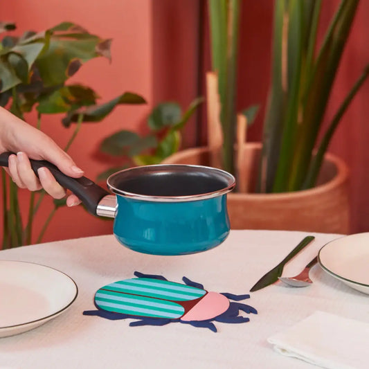 Casserole en émail turquoise avec manche noir et bord argenté, plat the beetles en matière résistante