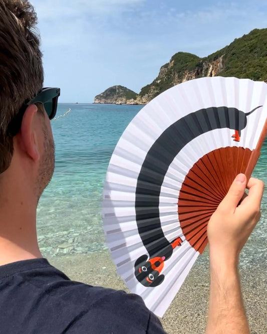 Éventail artisanal pliable blanc avec teckel noir et lattes en bois brun