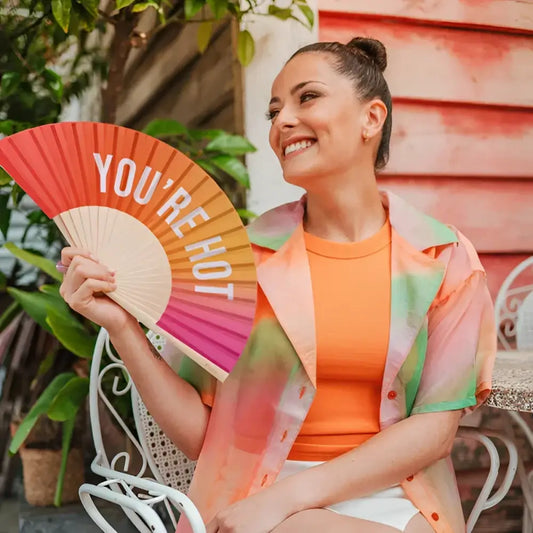 Femme tenant un eventail you are hot pour un look stylé et coloré