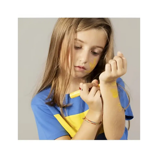 Jeune fille dessinant sur son bras avec un feutre de tatouage temporaire enfant jaune