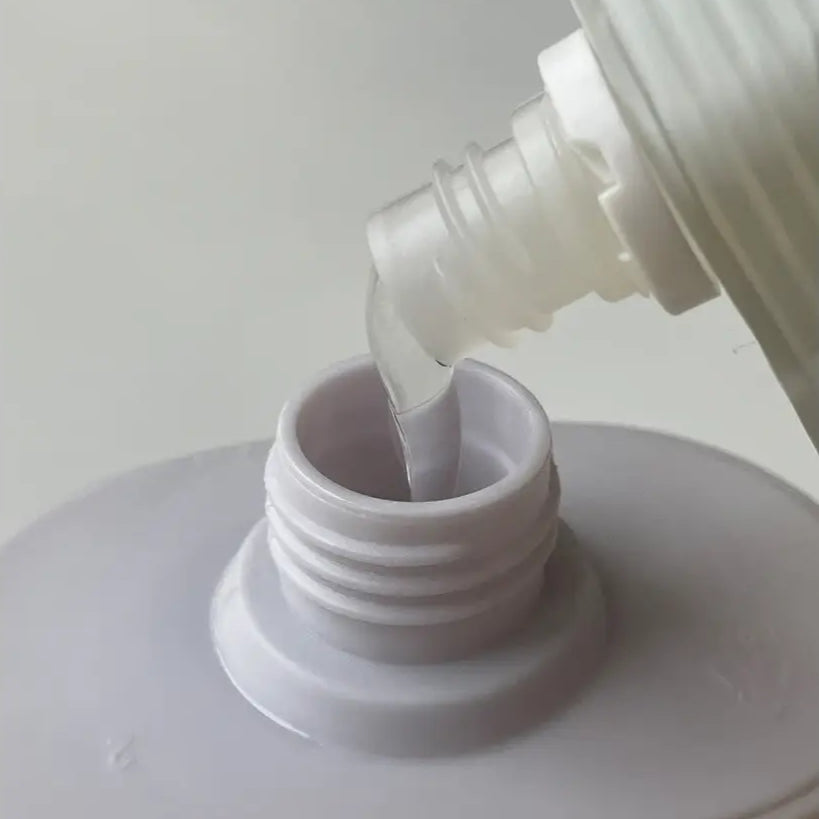 Liquide clair versé dans une bouteille pour gel douche hydratant aux probiotiques Margarita Spirit