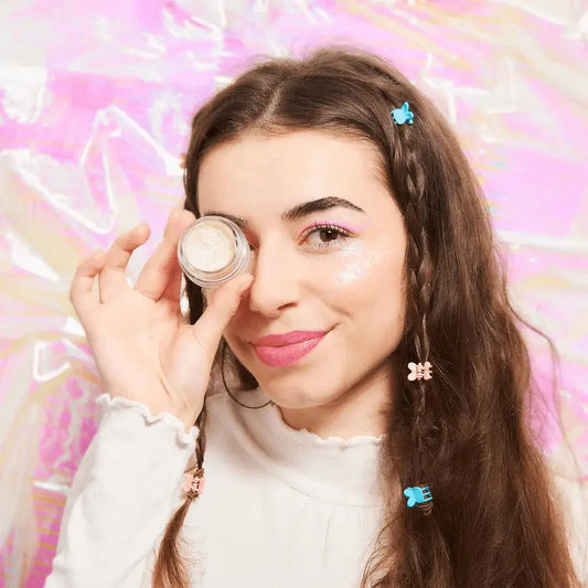 Jeune femme souriante applique Gel Pailleté Nuit Blanche sur l’œil