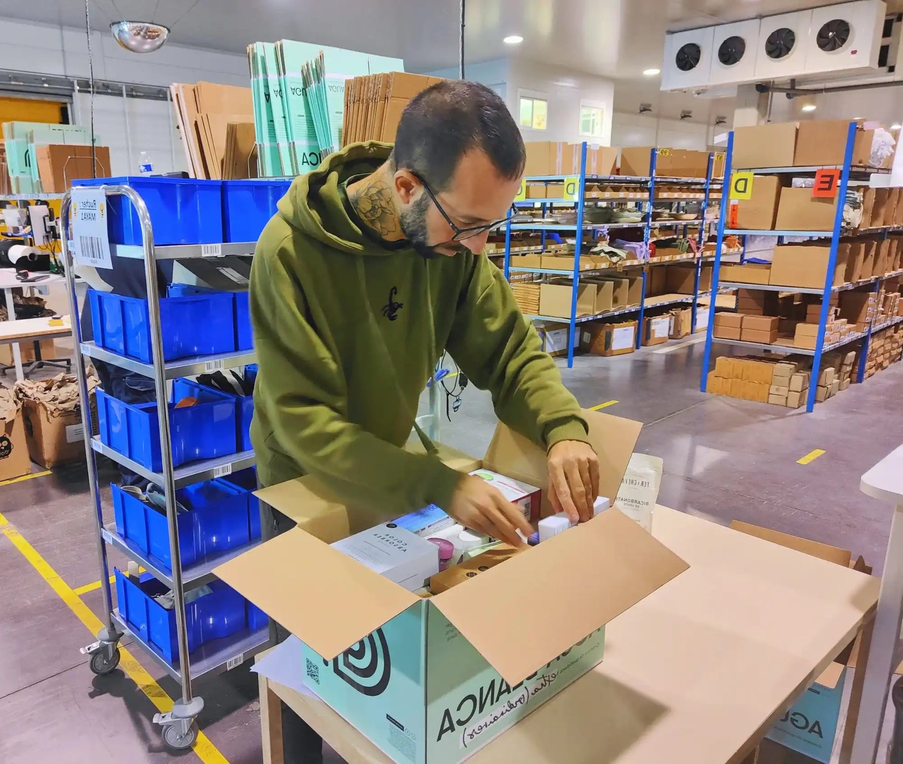 Un homme emballant des objets dans une boîte en carton.
