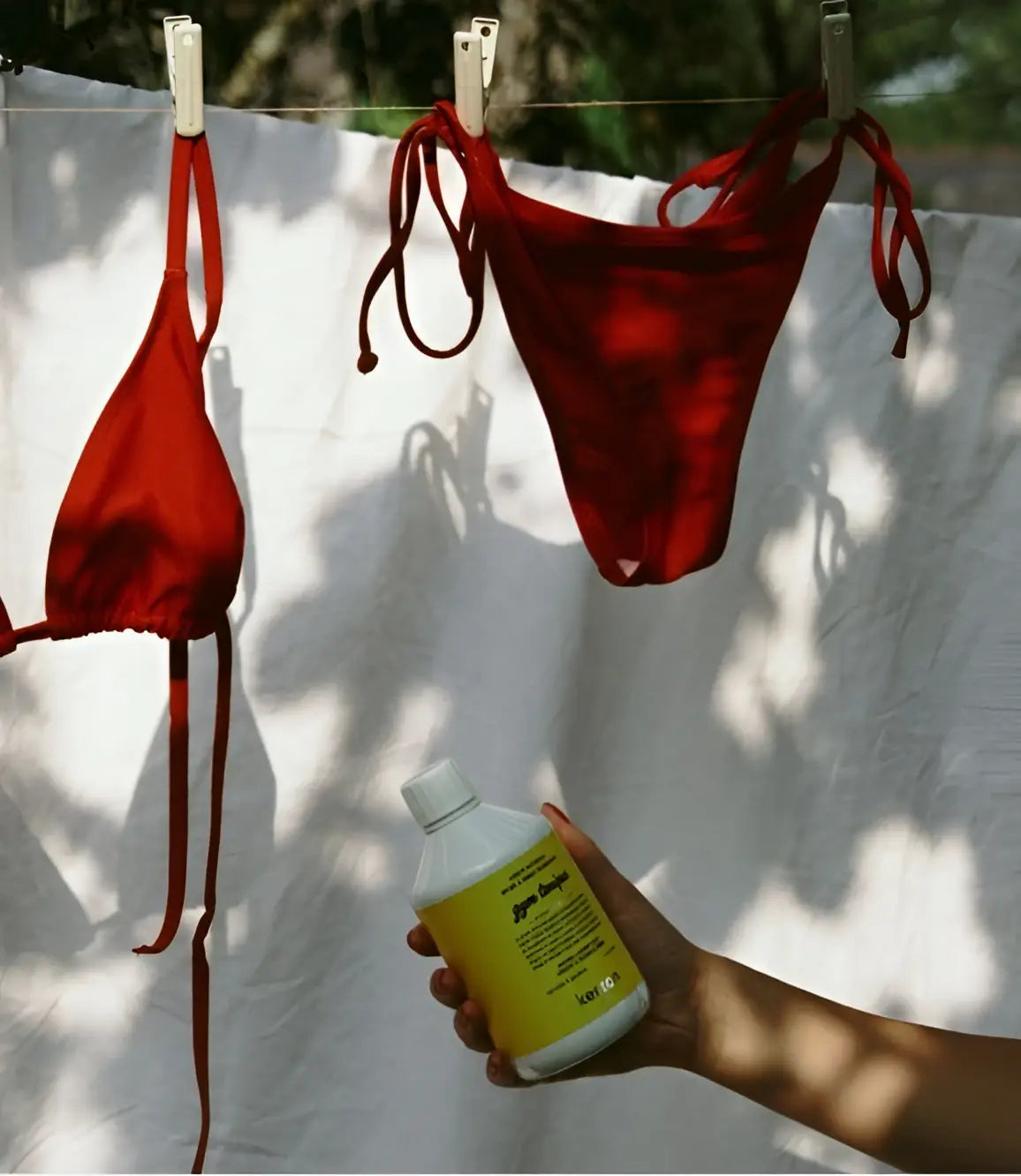 Main de Lush tenant lessive naturelle pour fibres techniques 500ml au parfum subtil