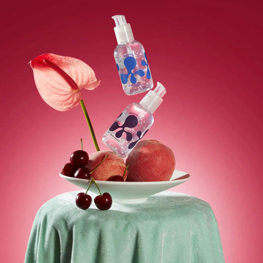 Deux bouteilles de lubrifiant naturel au-dessus d’un bol de fruits