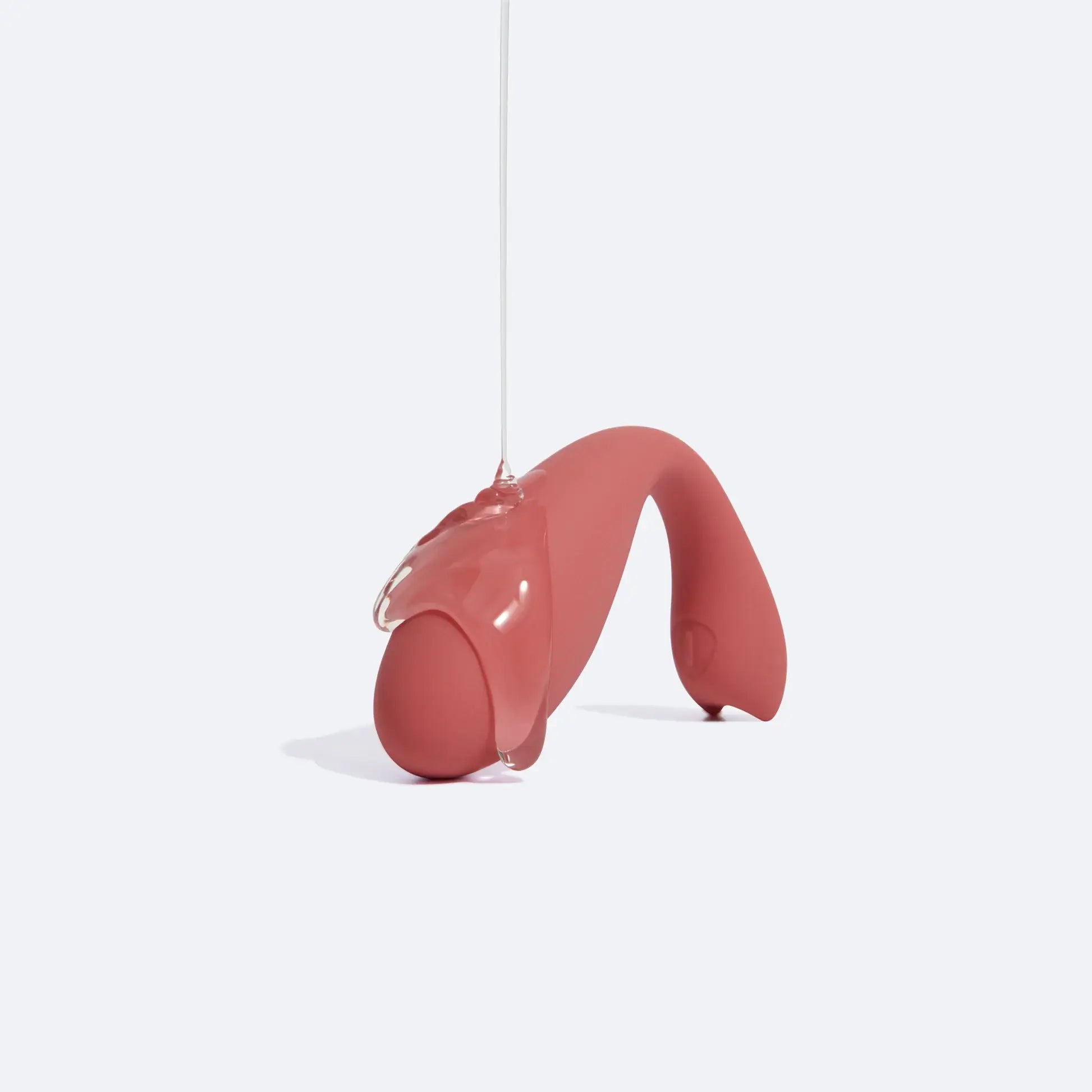 Jouet sexuel rose saumoné arrosé de lubrifiant naturel transparent et luisant