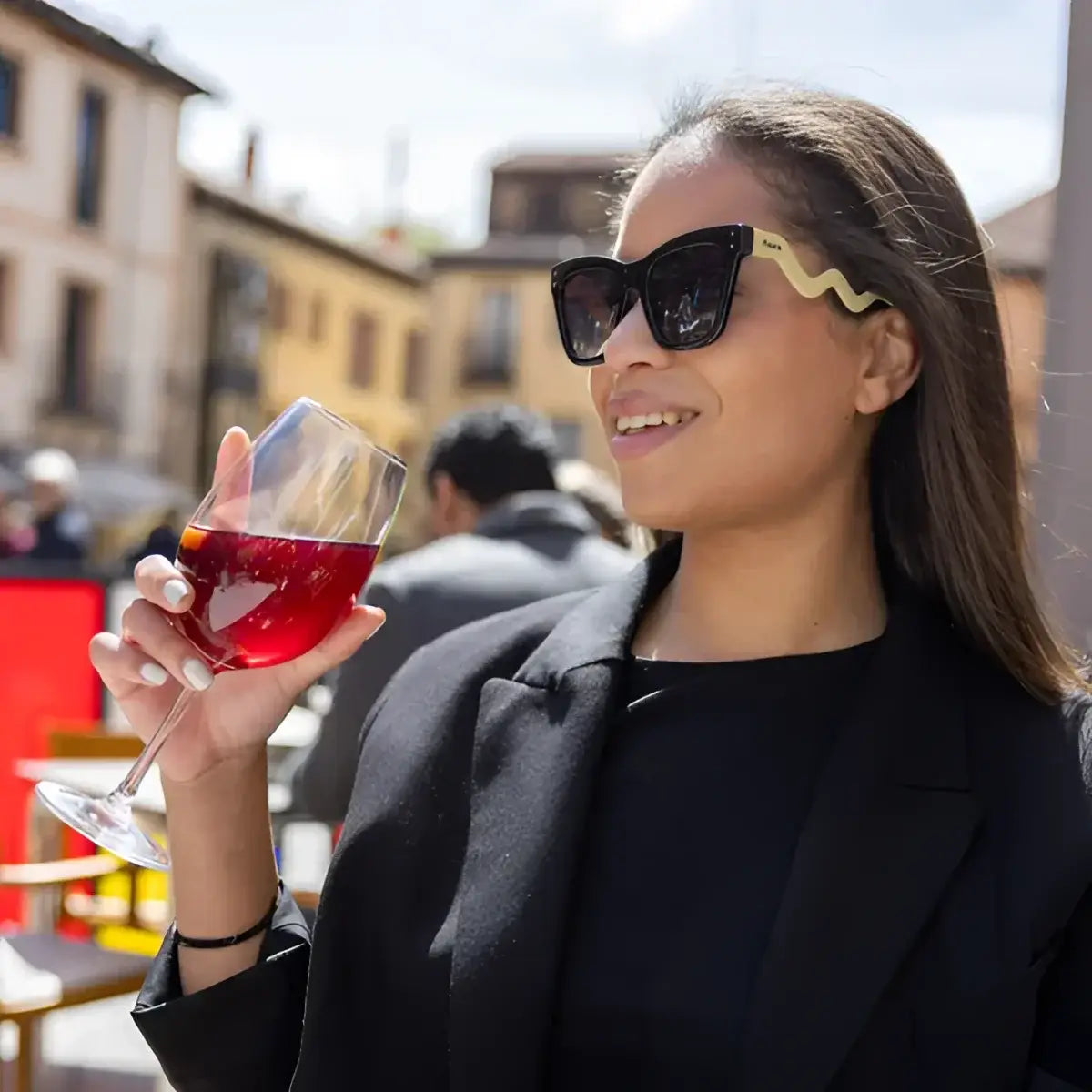 Femme en lunettes All You Need is Love tenant un verre de vin rouge, message positif qu’un simple accessoire