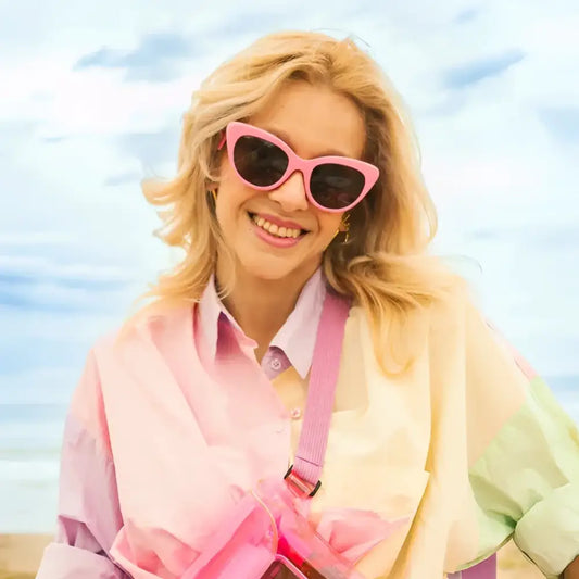 Femme souriante avec lunettes de soleil pink et shirt pastel, better late than ugly