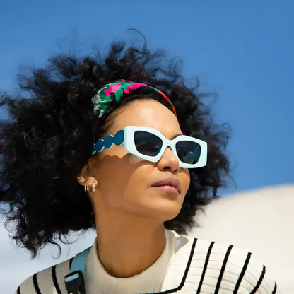 Femme aux cheveux bouclés en lunettes soleil Sweet Dreams esprit rêveur