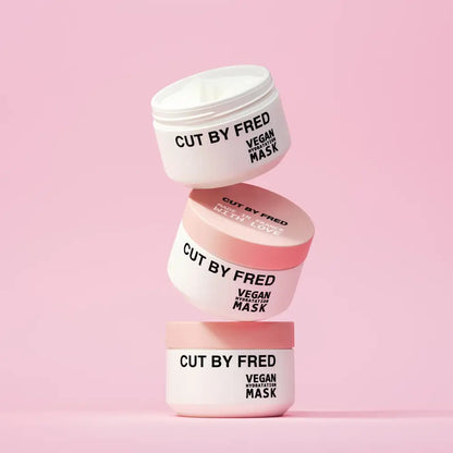 Trois pots empilés de Masque soin hydratant cheveux secs vegan en packaging blanc et rose