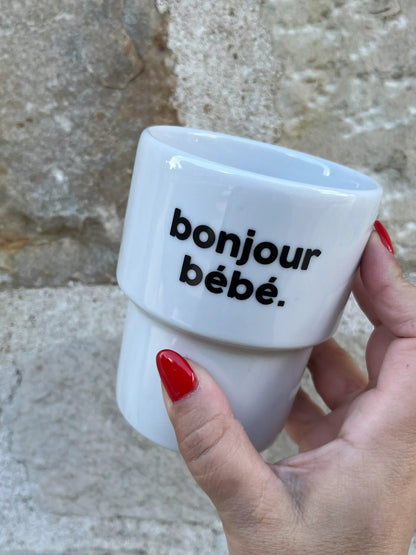 Tasse en céramique blanche ’bonjour bébé’ tenue par main aux ongles rouges, mug bonjour pour bonne humeur quotidienne