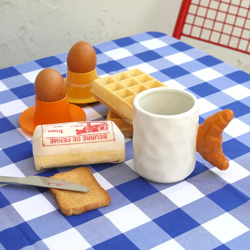 Petit-déjeuner avec œufs, beurre, gaufres et mug Croissant au design gourmand