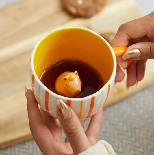 Tasse surprise capybara avec cochon orange flottant dans liquide foncé